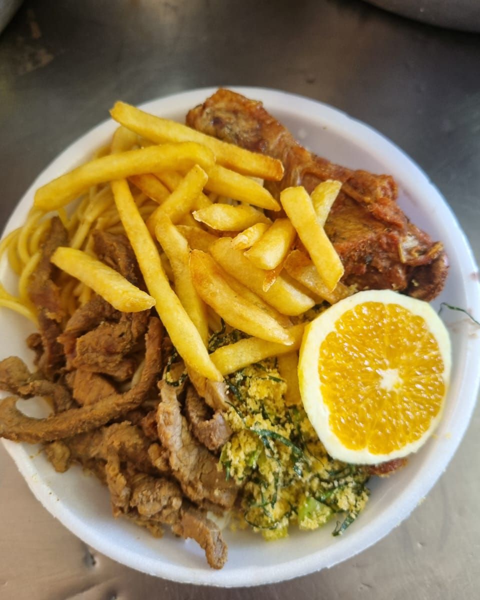 Prato com arroz, feijão, batata frita, macarrão alho e óleo, tiras de carne bovina, frango frito, laranja, farofa de couve